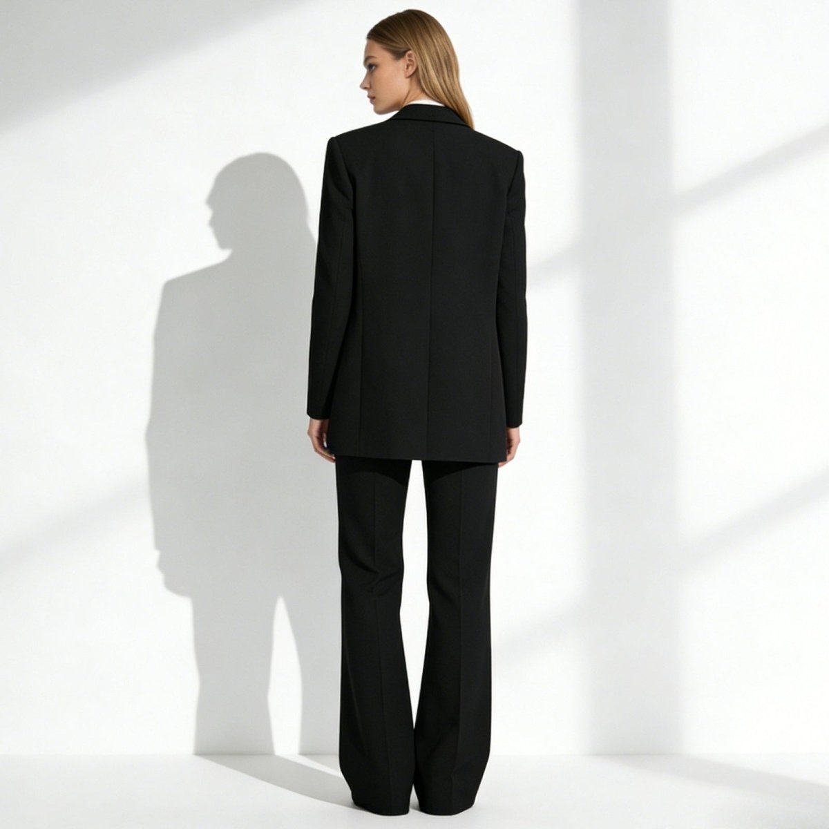 Back view of the Kouvr Fashion Kate suit, highlighting the clean tailoring of the blazer and the elegant drape of the wide-leg crepe trousers.