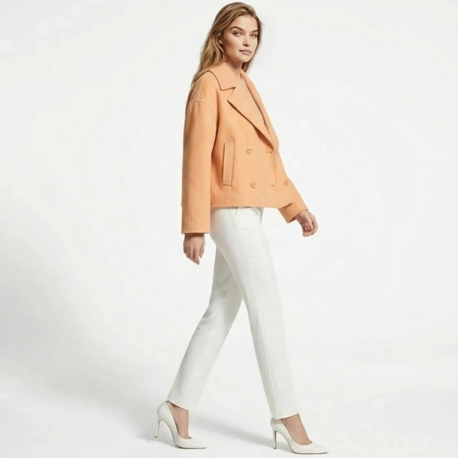 Front view of the Kouvr Katherine double-breasted cropped wool coat in a soft peach color, showcasing the boxy fit and tailored lapels.