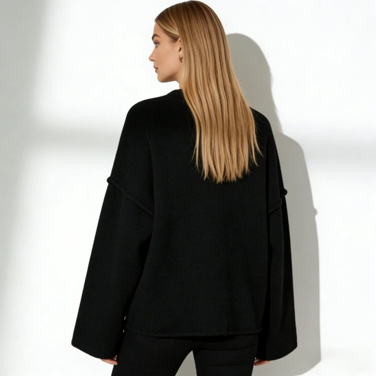 Back view of the Kouvr Krystal oversized black sweater, showing the clean lines and dropped shoulder construction.