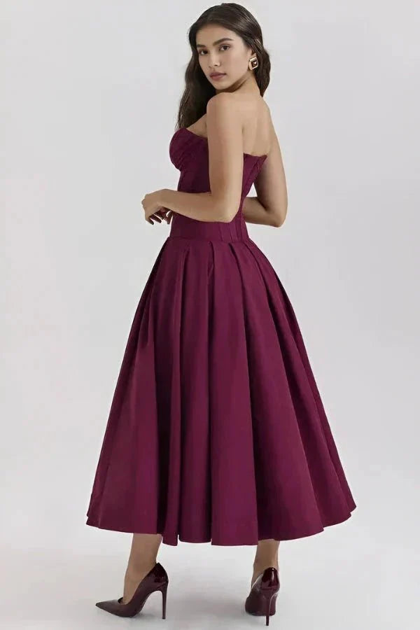 Model wearing Kouvr Fashion's burgundy strapless corset midi dress for a formal event