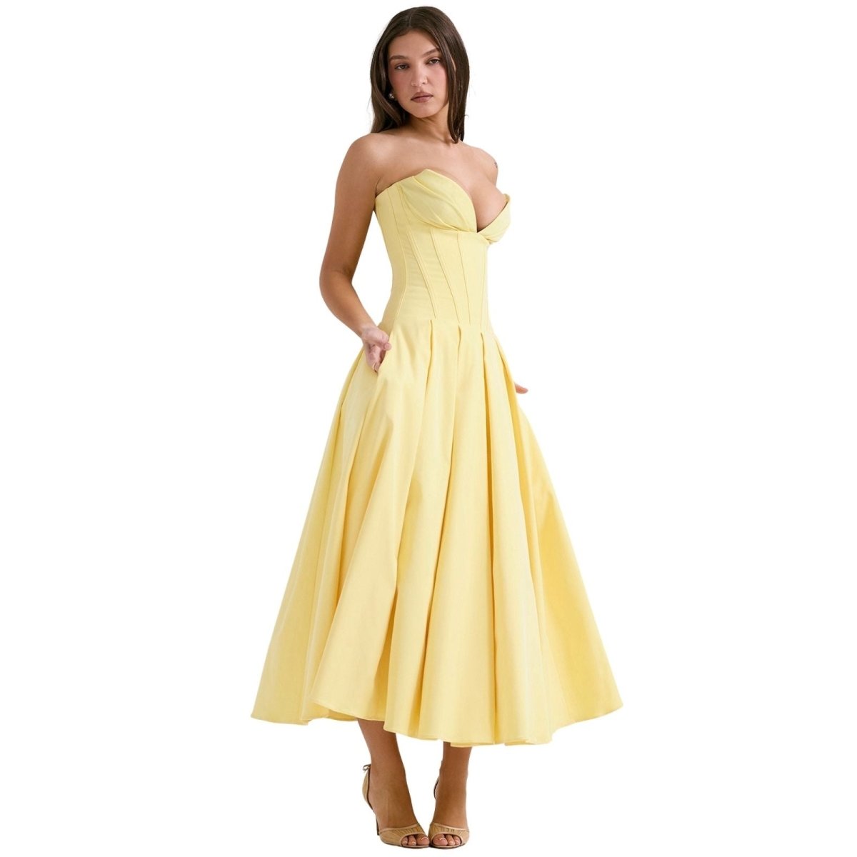 Model with hand in the side pocket of the kouvr-laarni-yellow-corset-midi-dress-front-strapless.