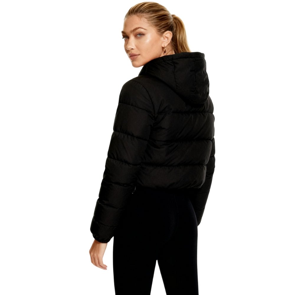 Woman wearing a black Kouvr puffer jacket on a white background