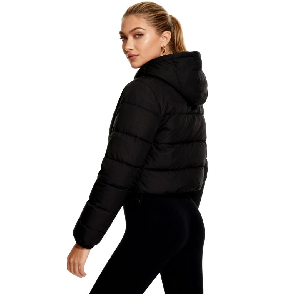 Woman wearing a black Kouvr puffer jacket on a white background