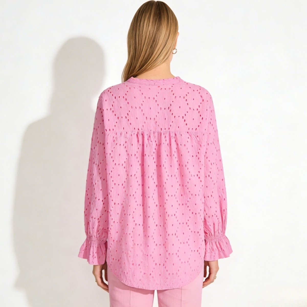 Back view of the Kouvr Lydia pink cotton blouse, detailing the broderie anglaise pattern and gathering at the yoke.