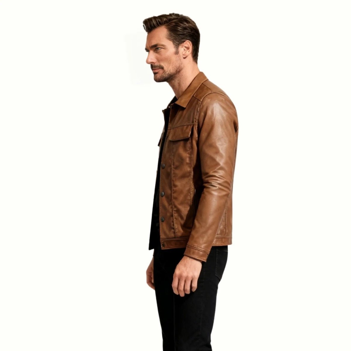 Side profile of a male model wearing the Kouvr brown leather trucker jacket, showing its slim fit and sleeve details.