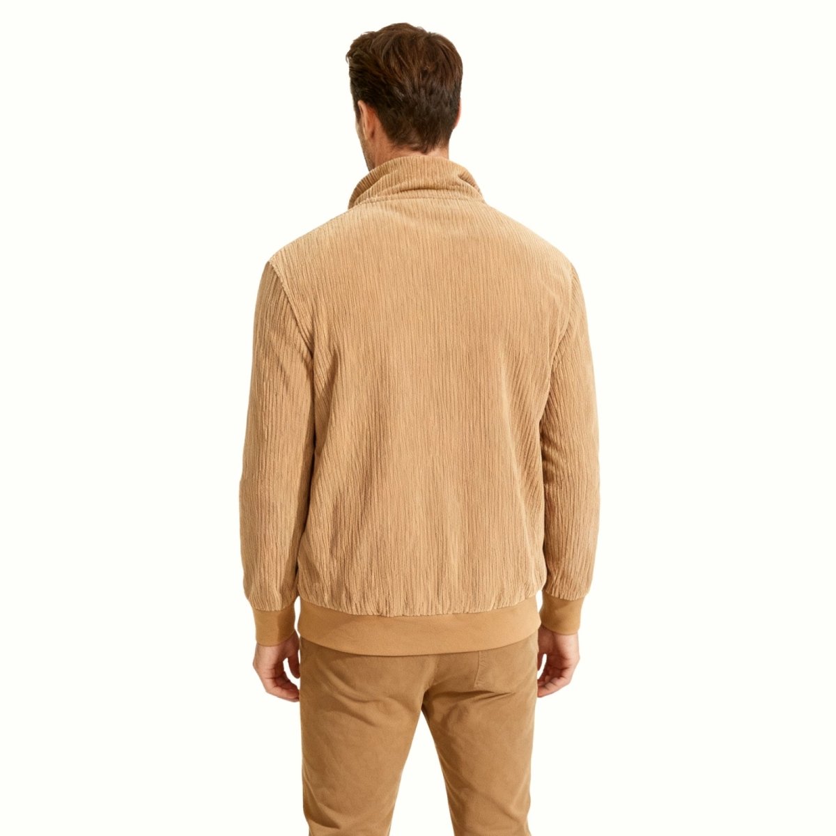 Rear view of a male model in the Kouvr beige corduroy bomber jacket, displaying the clean back panel and ribbed hem detail.