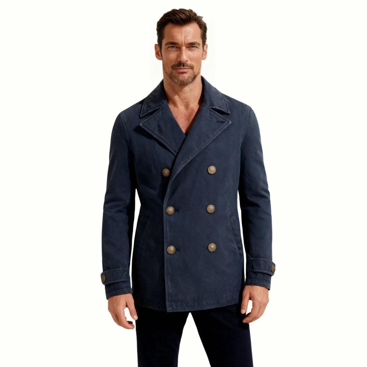 Model wearing the Kouvr men's garment-dyed cotton peacoat in a washed navy blue, showing the classic double-breasted front and fit.