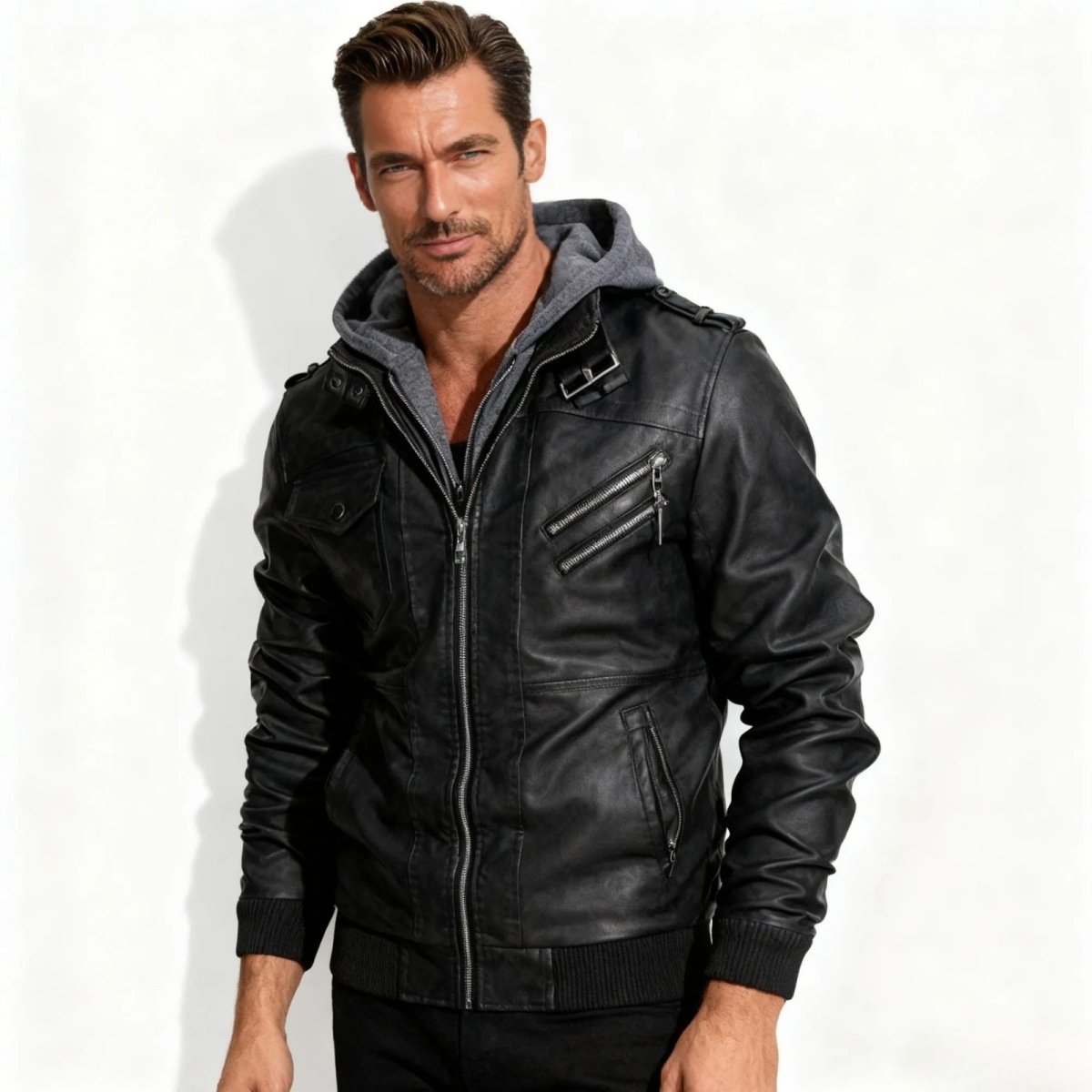 Model wearing the Kouvr men's black hooded faux leather moto jacket, facing forward with a white background.