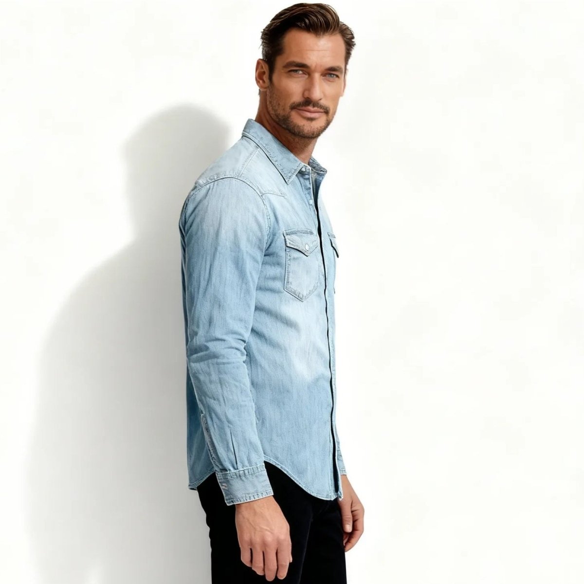 Man wearing a light blue Kouvr denim shirt against a white background
