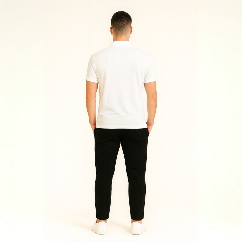 Model wearing the Kouvr white slim fit polo shirt with black trousers.