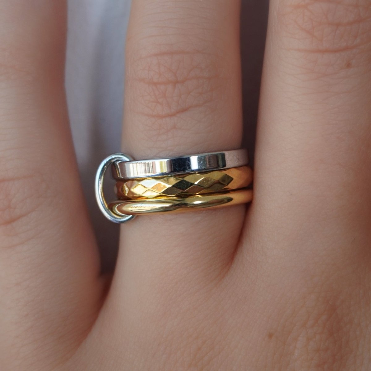 Kouvr mixed metal stacking ring set with gold and silver bands on a woman's finger.