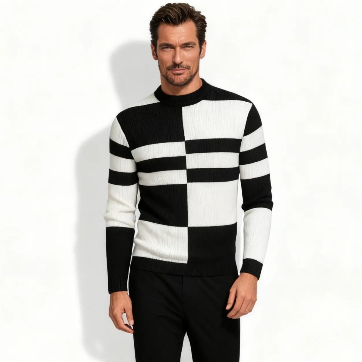 A male model wearing the Kouvr Nerthus black and white colorblock mock neck sweater, viewed from the front against a white background.