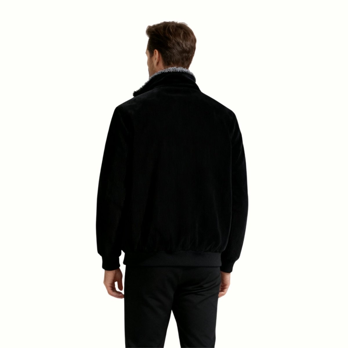 Back view of a man wearing the Kouvr Nickn black corduroy jacket, showing the ribbed hem and clean lines.