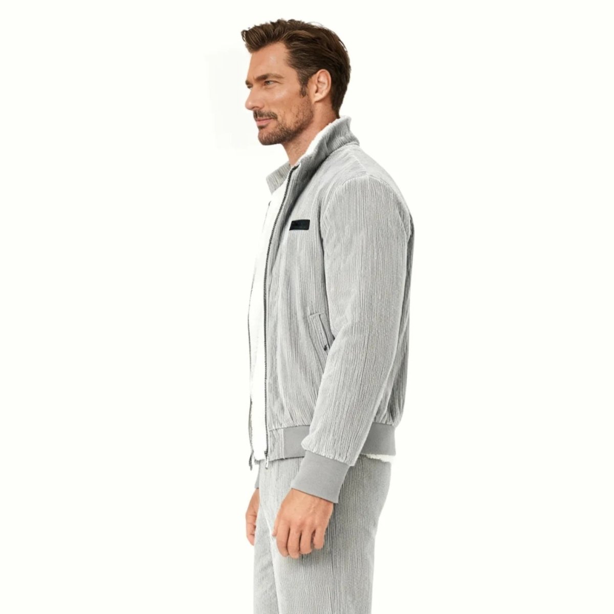 Side profile of a man in a grey full-zip corduroy bomber jacket showing the fit and sleeve length.