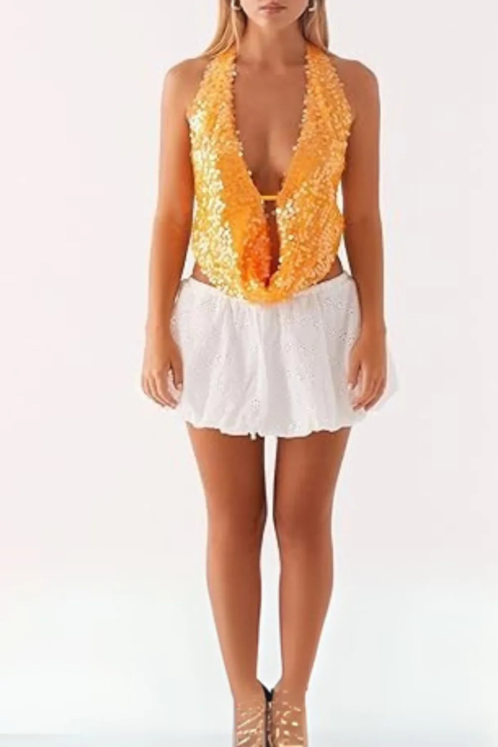 Model wearing Kouvr's Rosette featuring an orange sequin backless halter top