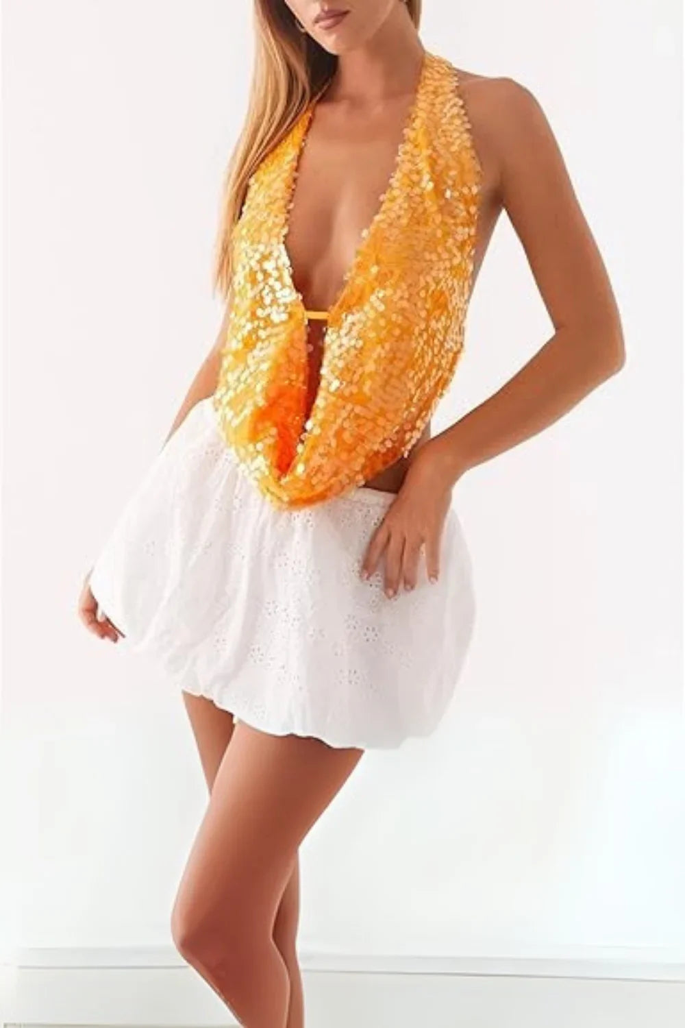 Model wearing Kouvr's Rosette featuring an orange sequin backless halter top
