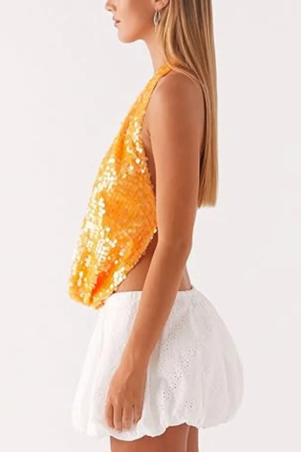Model wearing Kouvr's Rosette featuring an orange sequin backless halter top