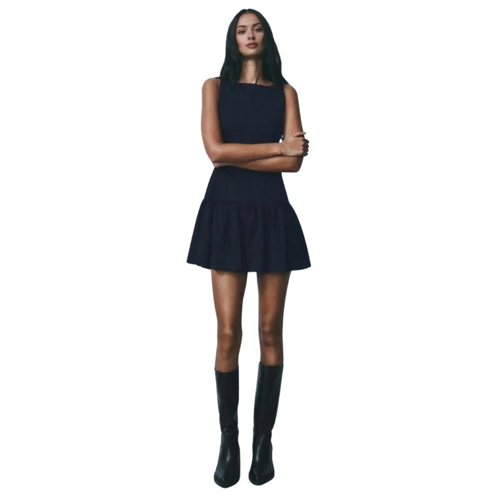 Woman wearing a navy Kouvr dress and boots on a white background