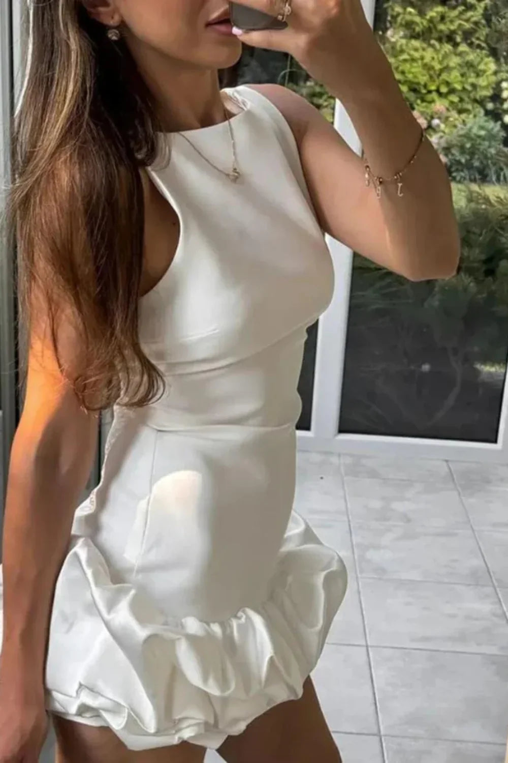 Model wearing Kouvr Fashion's white sleeveless bubble hem mini dress