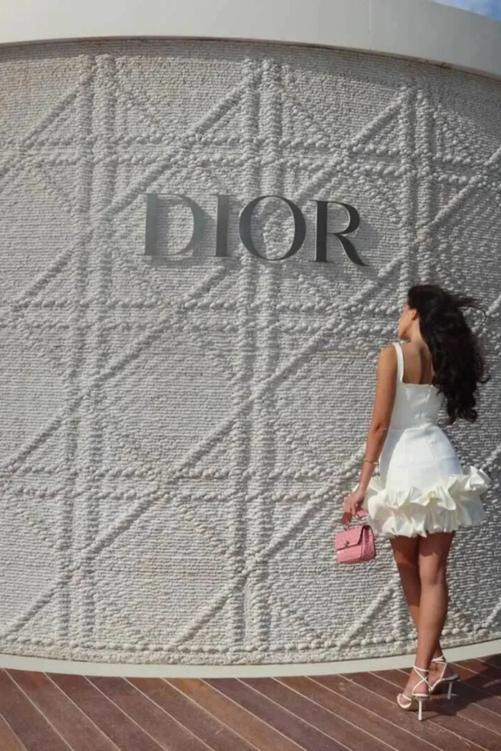 Model wearing Kouvr Fashion's white sleeveless bubble hem mini dress