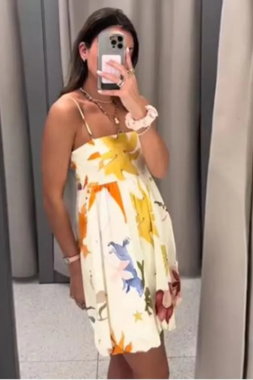 Woman wearing Kouvr Solana artistic print voluminous mini dress in a sunny outdoor setting