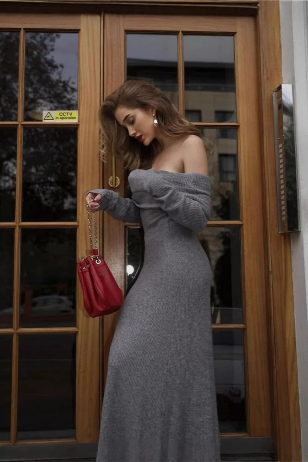 Model wearing the Kouvr Ingrid gray off-the-shoulder ribbed knit maxi dress outdoors