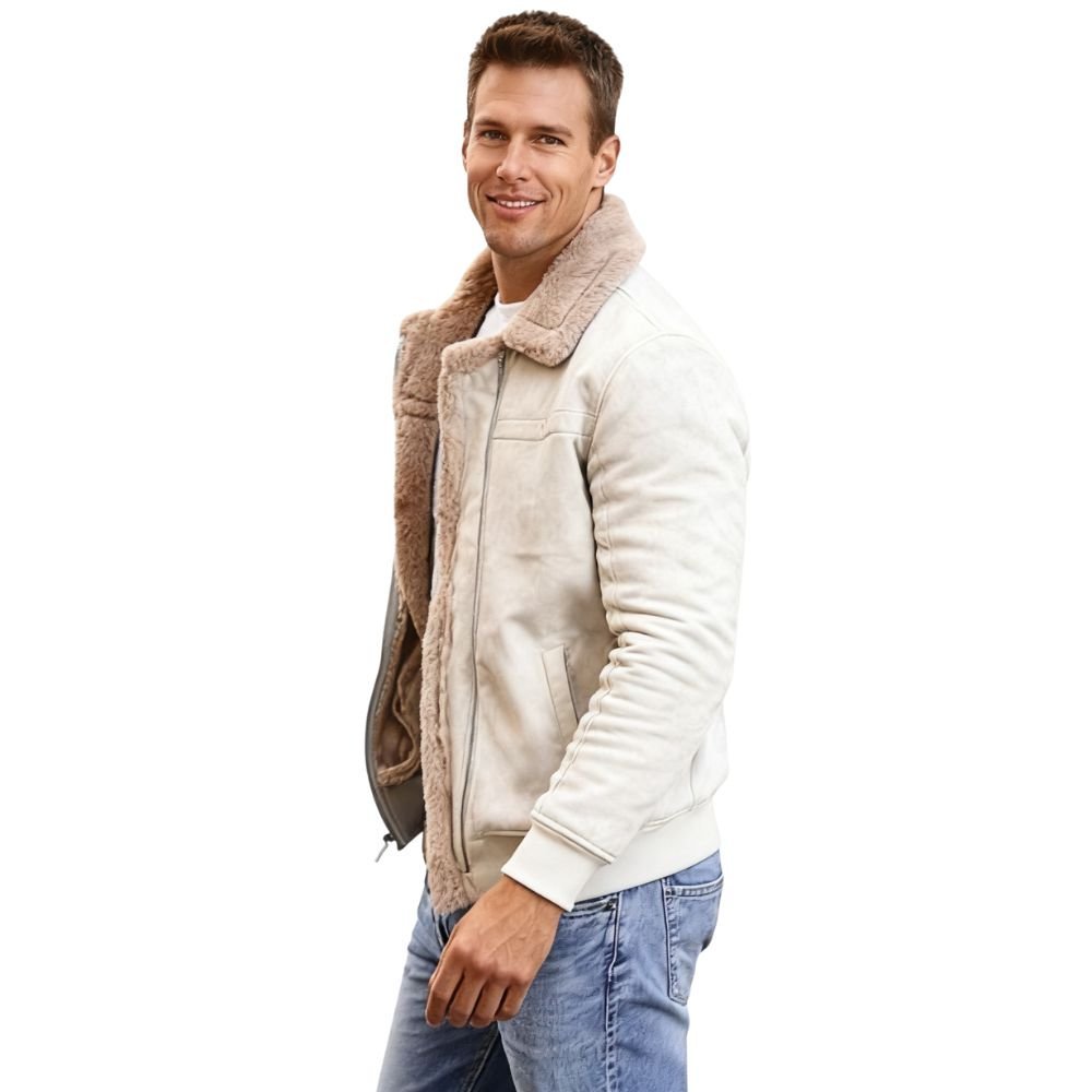 Man wearing a beige kouvr shearling jacket with a white shirt and blue jeans on a white background