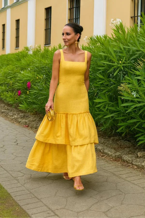 Model wearing the Kouvr Valeria canary yellow tiered ruffle maxi dress at an outdoor event