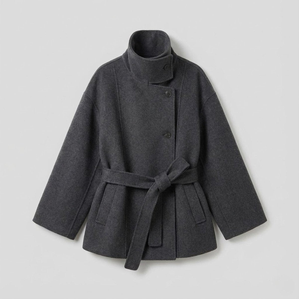 Flat lay of the dark gray Kouvr verna funnel neck coat, showing the asymmetrical button closure and tie belt.