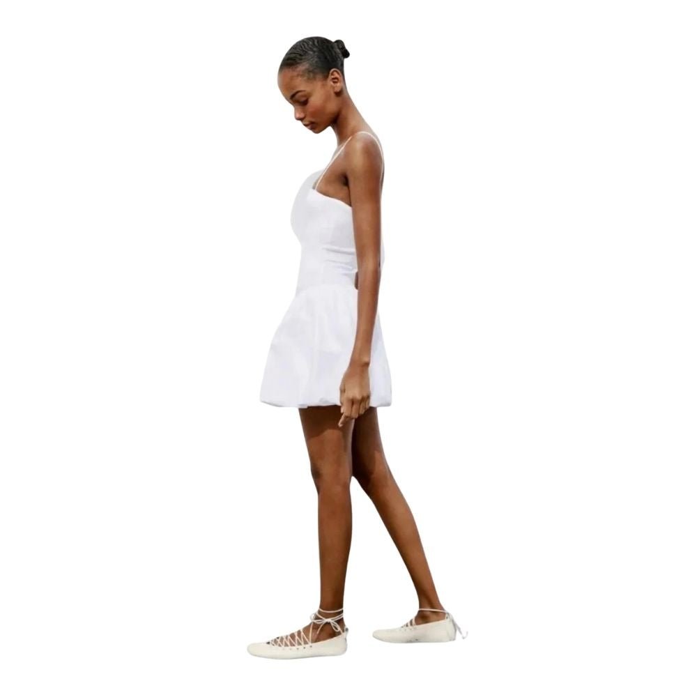 Model wearing the Kouvr white bubble hem mini dress with spaghetti straps