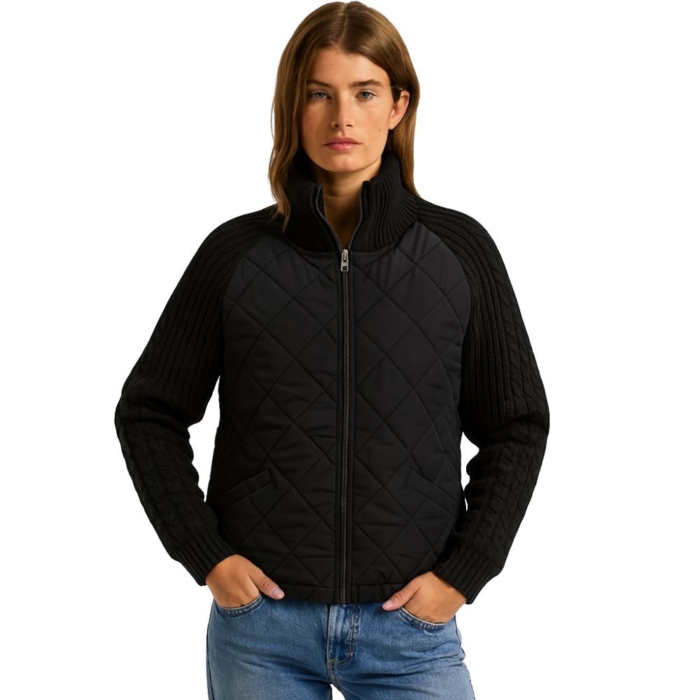 Model wearing the black Mika hybrid jacket by Kouvr, showing the quilted front and knit sleeves