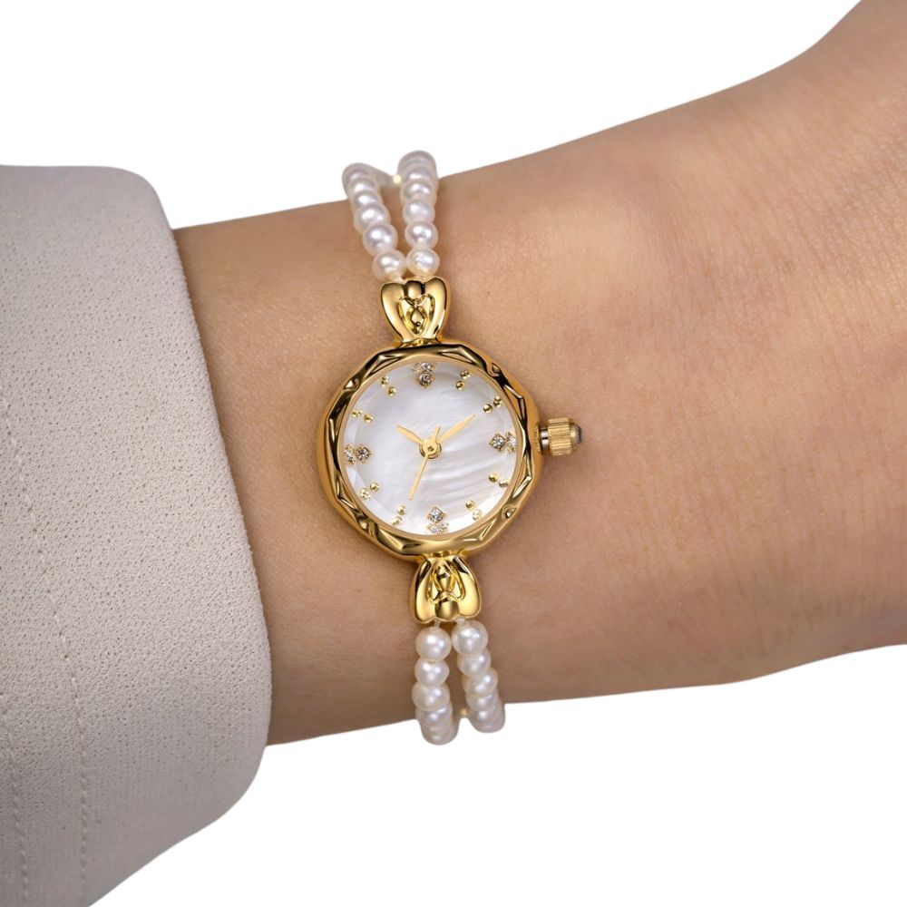 Kouvr women's elegant gold watch with a double strand real pearl bracelet and mother of pearl dial on wrist