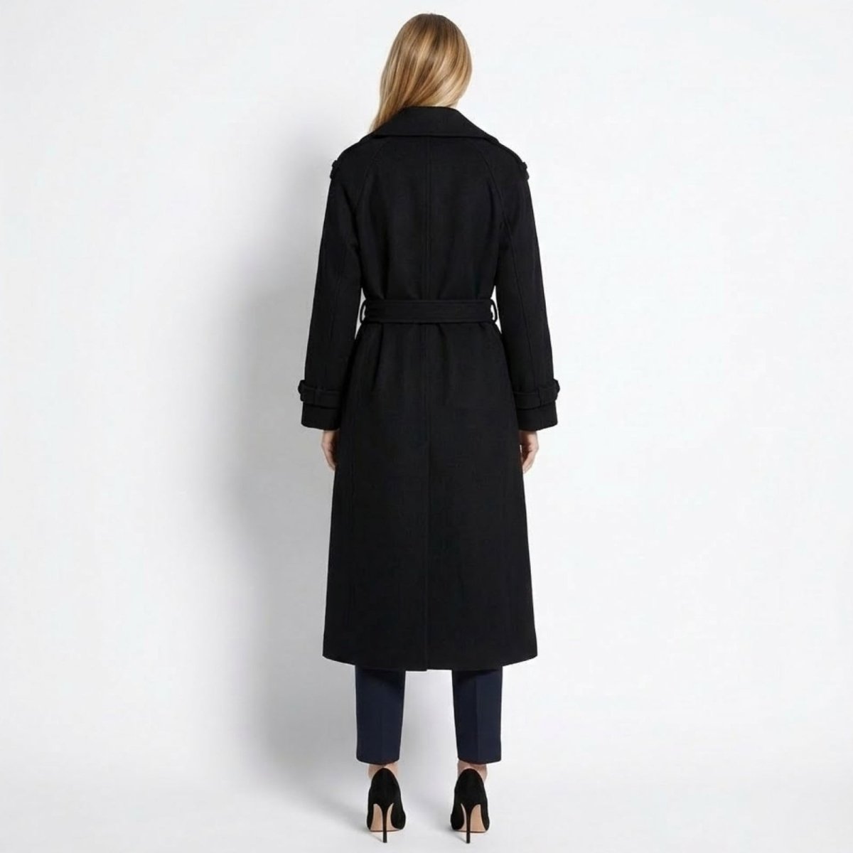 Back view of the Kouvr women's long black wool trench coat, showing the tied belt, classic collar, and clean lines.
