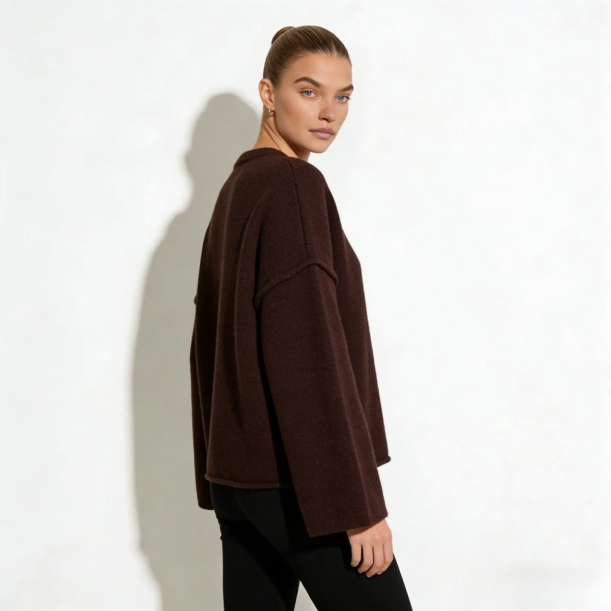 Side profile of a model in the Kouvr dark brown wide-sleeve sweater.