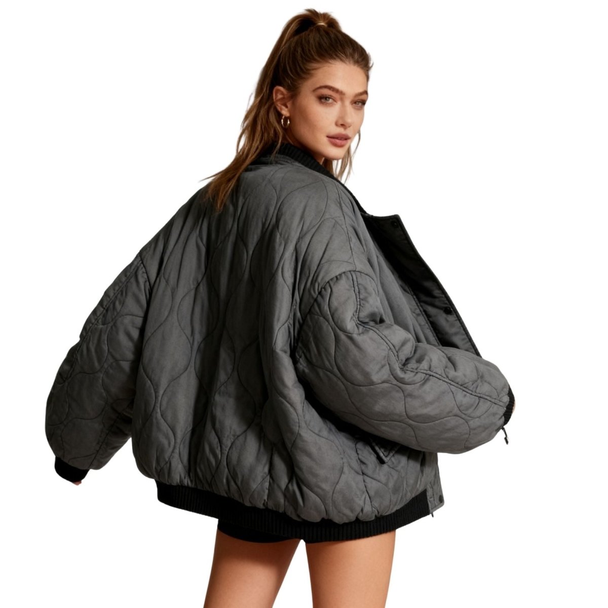 Back view of the Kouvr oversized quilted bomber jacket showing the unique wave quilting pattern.
