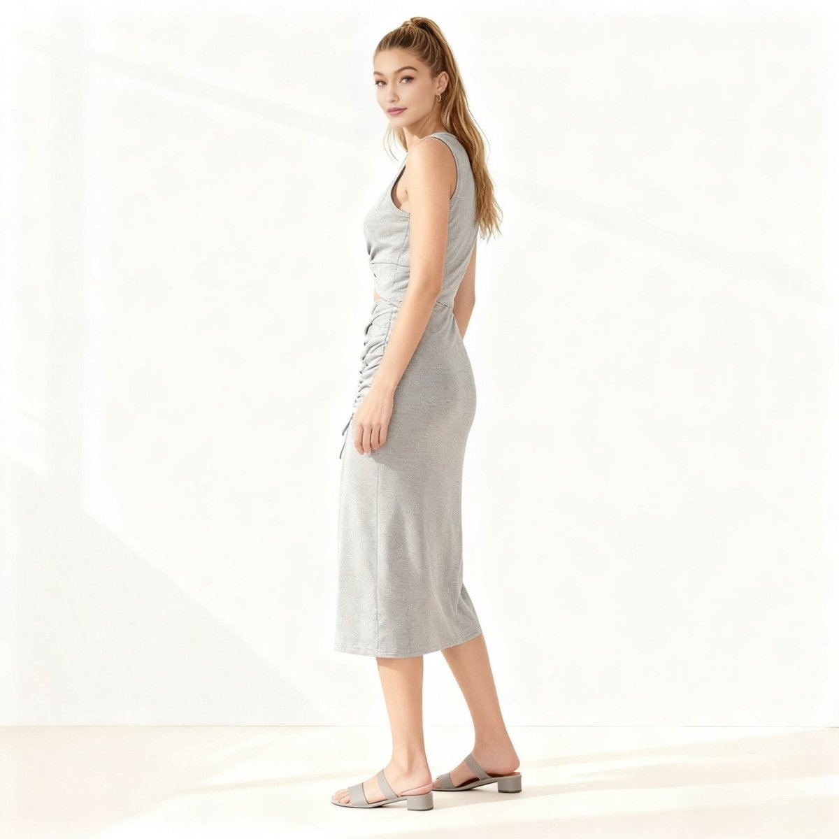 Woman wearing a grey Kouvr sleeveless dress on a white background