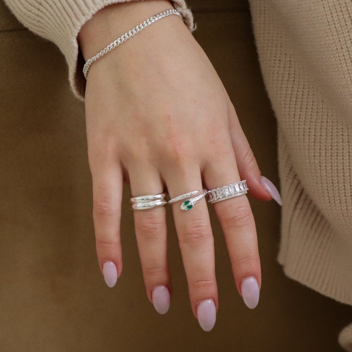 Close-up of hands with wearing the silver Kouvr Double Dome Ring with other silver rings.
