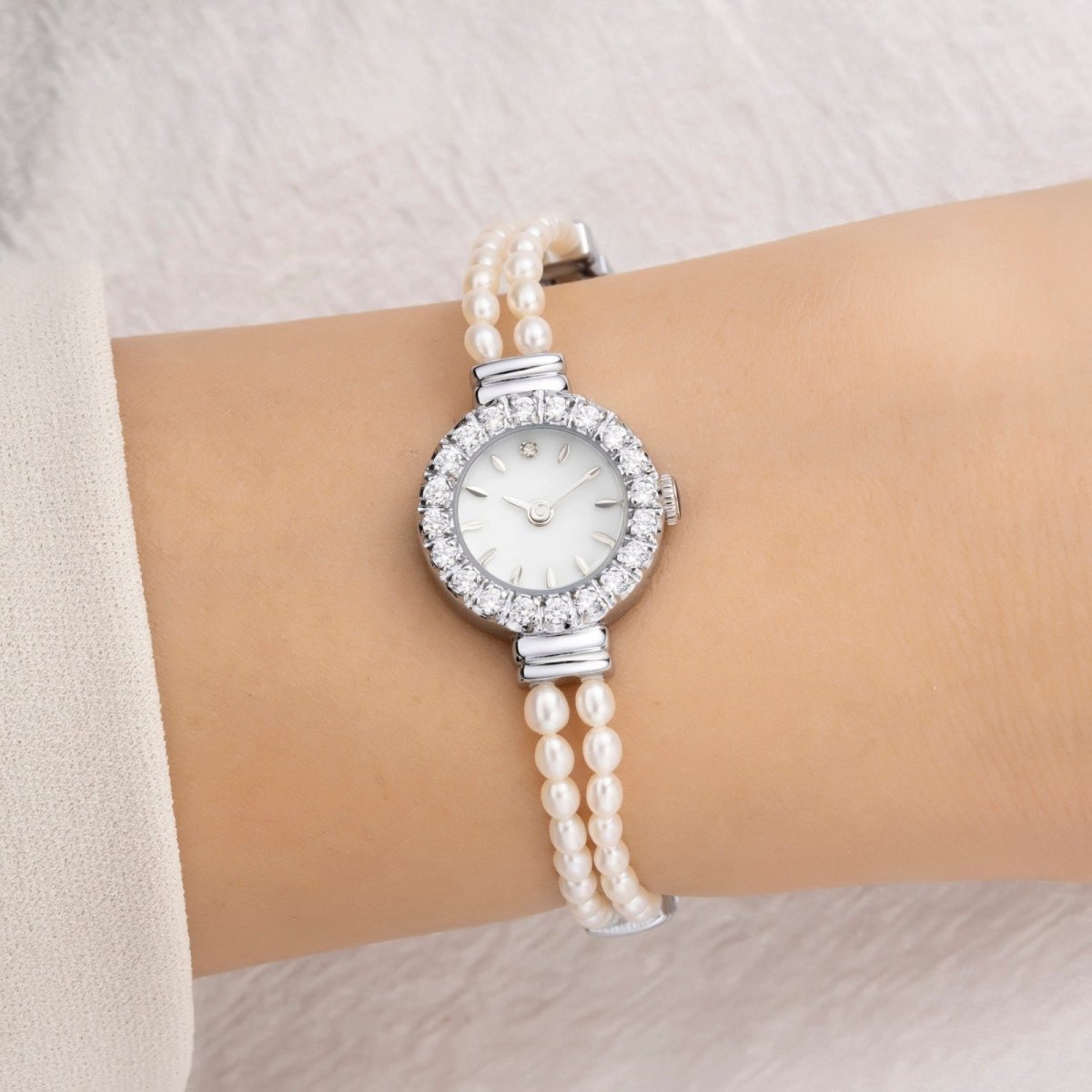 Kouvr Pearl bracelet watch on a wrist with a neutral background